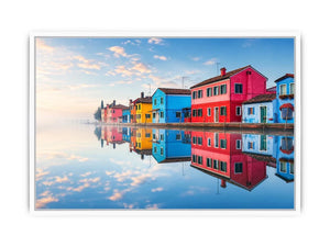 Bright colorful coastal village wall art featuring vibrant European houses reflected in calm water with soft fog and minimalist atmospheric tones.