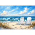 White beach chairs overlooking calm ocean waves on a sandy coastal shoreline