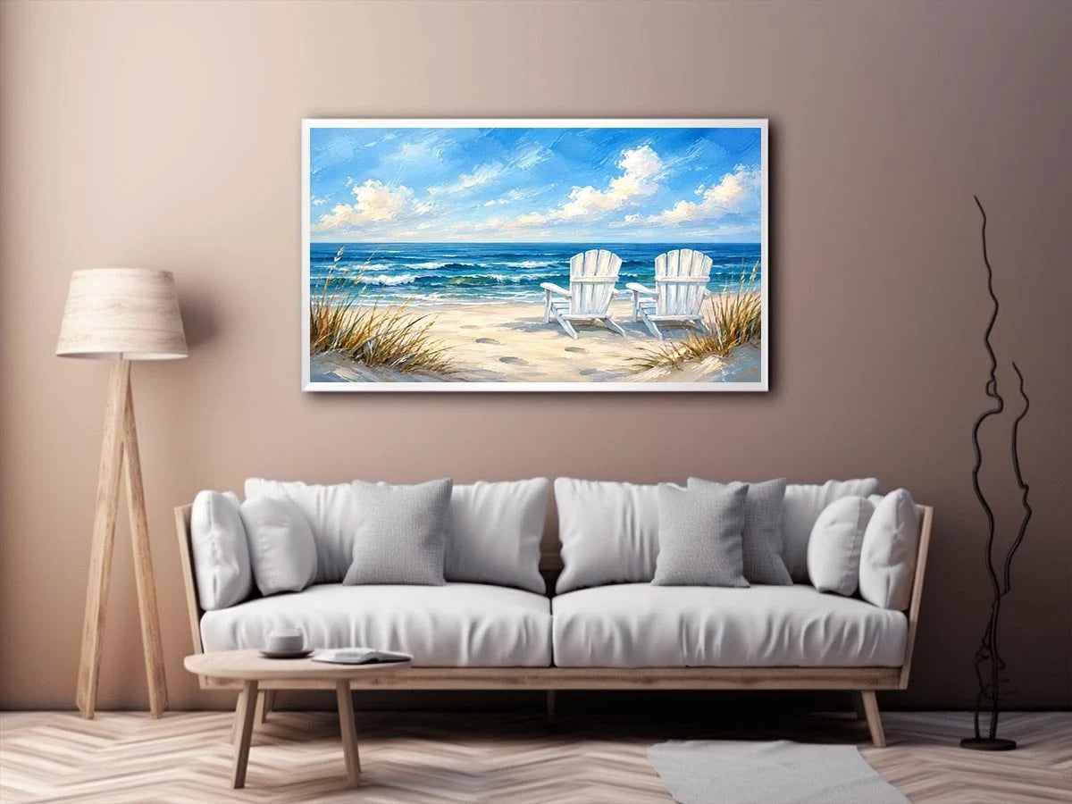 White beach chairs overlooking calm ocean waves on a sandy coastal shoreline