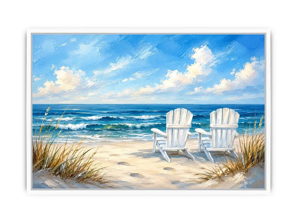 White beach chairs overlooking calm ocean waves on a sandy coastal shoreline