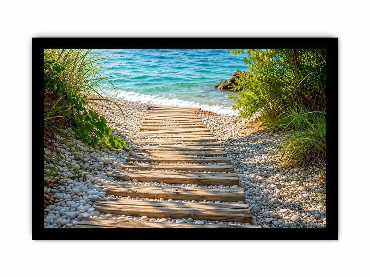 Rustic wooden pathway leading across a pebble beach toward turquoise ocean waves