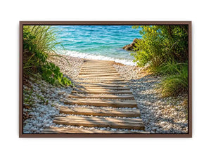 Rustic wooden pathway leading across a pebble beach toward turquoise ocean waves