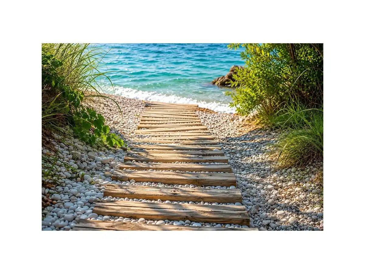 Rustic wooden pathway leading across a pebble beach toward turquoise ocean waves