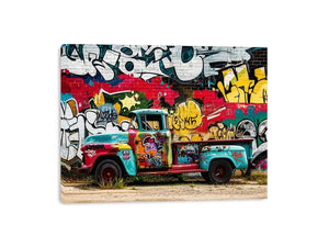 Vintage graffiti pickup truck wall art with colorful urban street mural background.