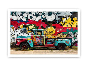Vintage graffiti pickup truck wall art with colorful urban street mural background.