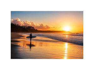 Lone surfer standing on a beach at sunset with golden reflections across calm ocean waves