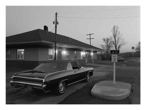 Black and white classic car photo with roadside building for office decor.