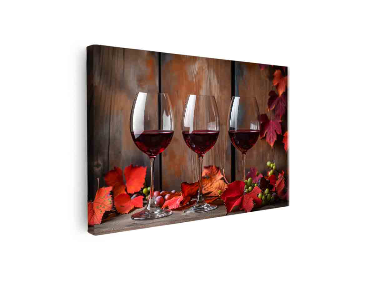 Three red wine glasses with autumn leaves and grapes for dining room decor.