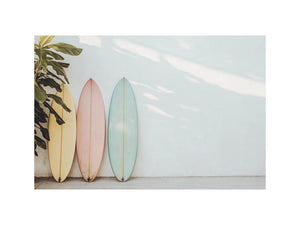 Pastel surfboards by a white wall for calm coastal bedroom decor.