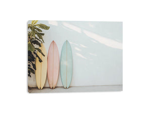 Pastel surfboards by a white wall for calm coastal bedroom decor.