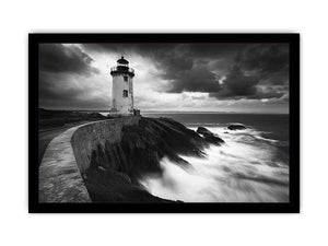 Moody black and white lighthouse wall art with storm clouds for modern living room decor.