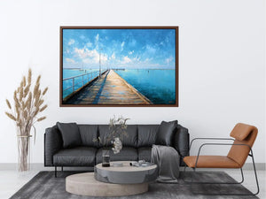 Coastal pier wall art featuring a sunlit boardwalk over calm blue ocean waters with textured impressionist brushstrokes and airy seaside tones.