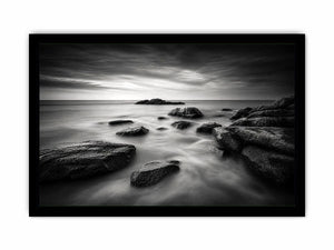 Black and white ocean wall art with dramatic coastal rocks, misty waves, and moody storm clouds in contemporary monochrome seascape style