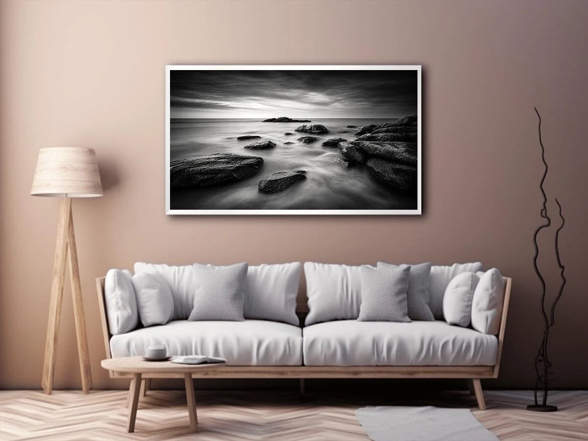 Black and white ocean wall art with dramatic coastal rocks, misty waves, and moody storm clouds in contemporary monochrome seascape style