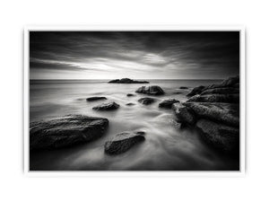 Black and white ocean wall art with dramatic coastal rocks, misty waves, and moody storm clouds in contemporary monochrome seascape style