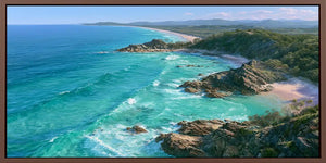 Panoramic coastal canvas art with turquoise ocean, rocky headlands, and beach scenery for modern living room decor.