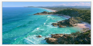 Panoramic coastal canvas art with turquoise ocean, rocky headlands, and beach scenery for modern living room decor.