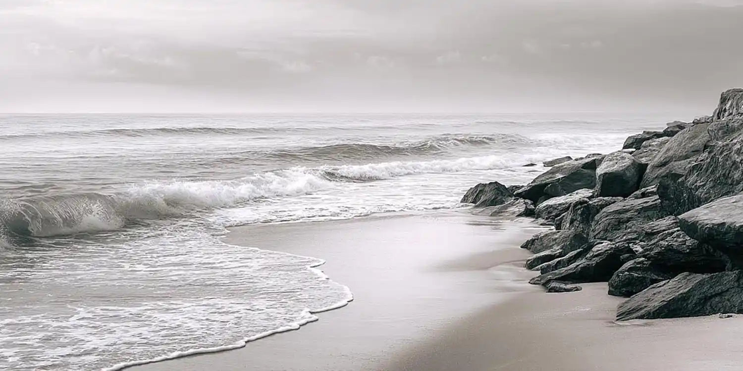 Neutral black and white coastal canvas art with rocks for calming bedroom decor.