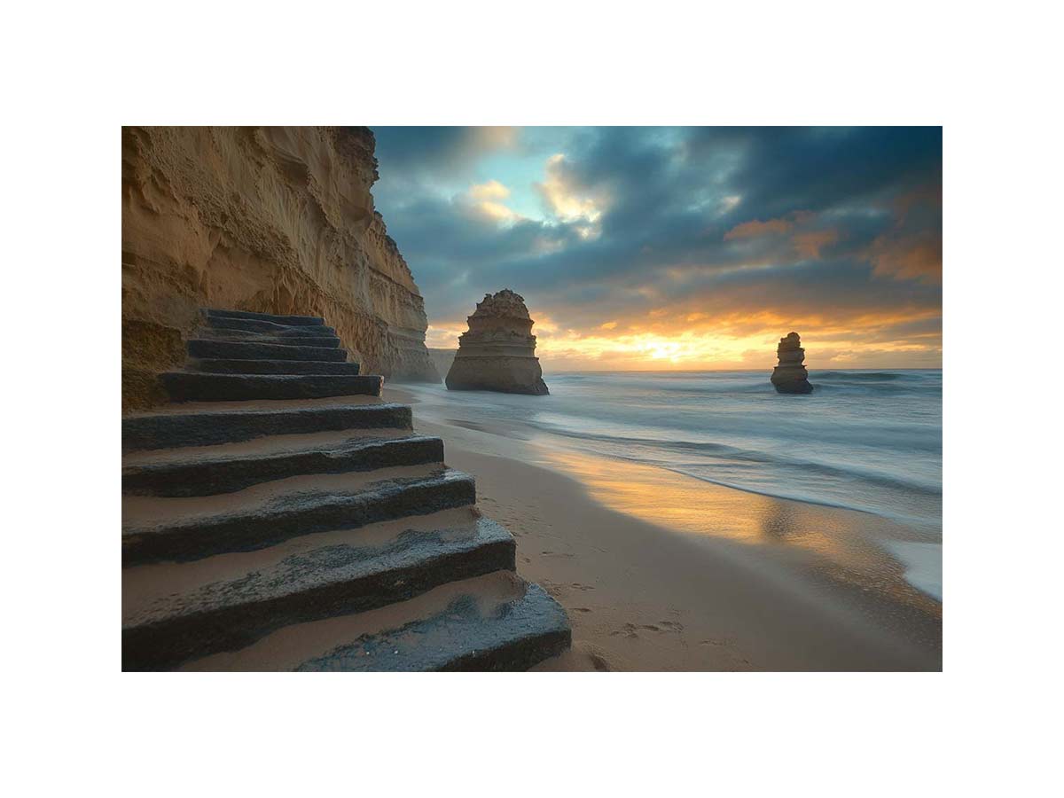 Moody coastal beach photograph with cliffs and stairs for luxury decor.