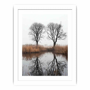 Misty winter trees reflected in still marsh water for serene vertical wall art.