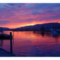 Sunset lake harbor canvas print with mountains and reflections for serene living room decor.