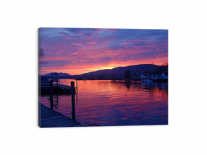 Sunset lake harbor canvas print with mountains and reflections for serene living room decor.