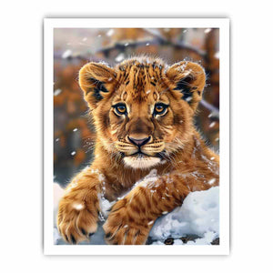 Young lion cub resting in snow with soft falling flakes for modern nurseries decor.